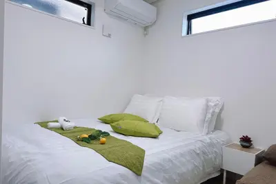 a white bed with a green blanket and fruits on it at Joy \u4e1c\u4eac\u6674\u7a7a\u5854 in Tokyo