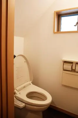 a bathroom with a toilet with the lid up at Joy \u62bc\u4e0a\u4e00\u6237\u5efa in Tokyo
