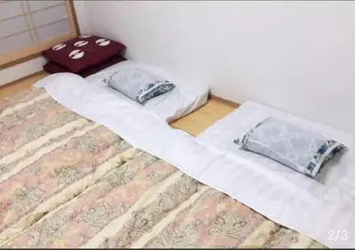 a bed with two pillows on top of it at Joy \u62bc\u4e0a\u4e00\u6237\u5efa in Tokyo