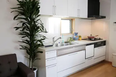 a kitchen with white cabinets and a potted plant at Joy \u62bc\u4e0a\u4e00\u6237\u5efa in Tokyo