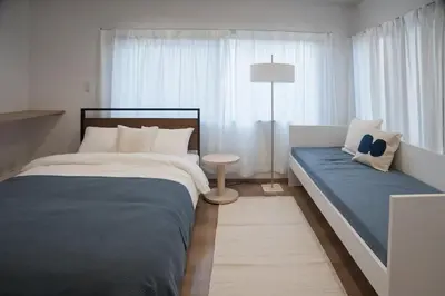 a bedroom with two beds and a table and a lamp at Higashi-Ikebukuro-5dk-TS0456 in Tokyo