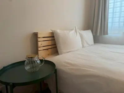 a bedroom with a bed with a table next to it at Bldg E Tokyo in Tokyo