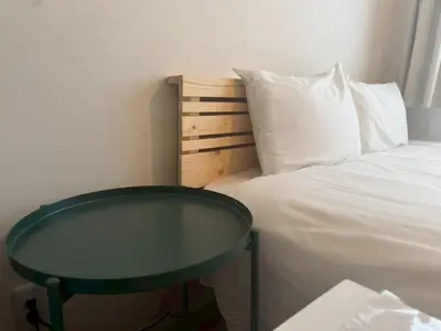 a bed with a green table next to a bed at Bldg E Tokyo in Tokyo