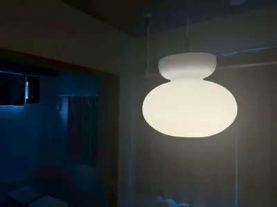 a white light hanging from the ceiling of a room at Bldg E Tokyo in Tokyo
