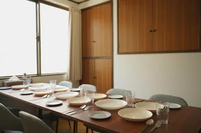 a long table with white plates and glasses on it at Wonderful stay TOKYO KURAMAE in Tokyo