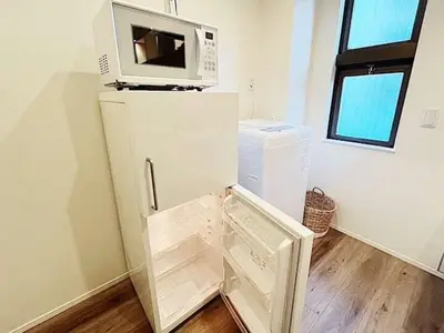 a white refrigerator with a microwave on top of it at Tokyo Stay GB Sugamo in Tokyo