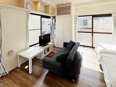 a living room with a couch and a tv and a bed at Tokyo Stay GB Sugamo in Tokyo