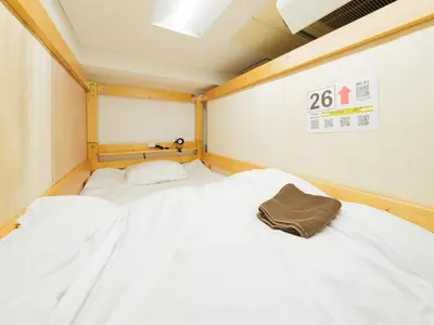 two beds in a room with white sheets at Dormitory \u30b5\u30fc\u30af\u30eb\u30c6\u30f3- Share Room For Male Only \u7537\u6027\u5c02\u7528\u30c9\u30df\u30c8\u30ea\u30fc in Tokyo