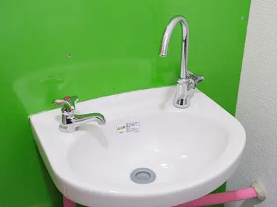 a white sink in a bathroom with a green wall at Dormitory \u30b5\u30fc\u30af\u30eb\u30c6\u30f3- Share Room For Male Only \u7537\u6027\u5c02\u7528\u30c9\u30df\u30c8\u30ea\u30fc in Tokyo