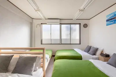 a room with two beds and a couch and a window at -Room MtFuji- Max 9 people 8 minutes to Shibuya 5 minutes to Shinjuku 1 minute to Harajuku 4 minutes walk from the station in Tokyo