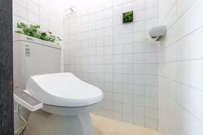 a bathroom with a white toilet and white tiles at -Room MtFuji- Max 9 people 8 minutes to Shibuya 5 minutes to Shinjuku 1 minute to Harajuku 4 minutes walk from the station in Tokyo