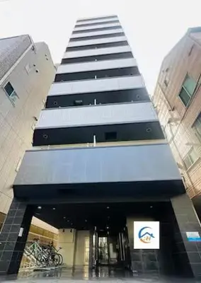 a tall building with a blue awning in a city at incense\u4e0a\u91ce\u6839\u5cb85\uff26 in Tokyo