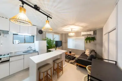a kitchen and living room with white cabinets and a couch at 2\u540d\u63a8\u5968\u99d2\u8fbc\u99c5Switch\u4ed8\u304d\u65bd\u8a2d in Tokyo