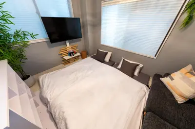 a bedroom with a white bed and a flat screen tv at 2\u540d\u63a8\u5968\u99d2\u8fbc\u99c5Switch\u4ed8\u304d\u65bd\u8a2d in Tokyo