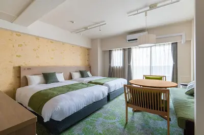 a hotel room with two beds and a table at Hotel TOKI \u5b63 in Tokyo