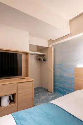 a bedroom with a bed and a flat screen tv at Hotel TOKI \u5b63 in Tokyo