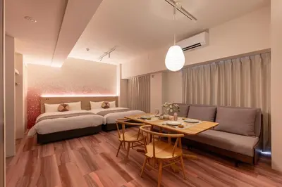 a bedroom with two beds and a table and a couch at Hotel TOKI \u5b63 in Tokyo