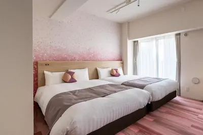 a bedroom with two beds and a pink wall at Hotel TOKI \u5b63 in Tokyo