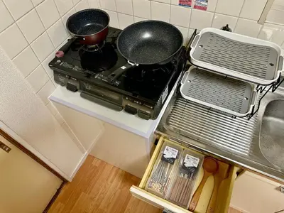 a kitchen with a stove with pots and pans on it at 7\u6642IN19\u6642OUT # \u6c60\u888b\u99c5\u3067\u306e\u304a\u8fce\u3048\u3042\u308a # \u30f4\u30a3\u30e9\u4e00\u8ed2\u5bb6\u8cb8\u5207 # \u99c5\u8fd18\u5206 # \u6c60\u888b\u99c510\u5206 # \u4e0a\u91ce\u99c513\u5206 # 7 00 IN19 00 OUT # Pick up Ikebukuro # Whole villa rental # 8 min to station # 10 min to Ikebukuro # 13 min to Ueno in Tokyo