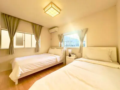a bedroom with two beds and a window at 7\u6642IN19\u6642OUT # \u6c60\u888b\u99c5\u3067\u306e\u304a\u8fce\u3048\u3042\u308a # \u30f4\u30a3\u30e9\u4e00\u8ed2\u5bb6\u8cb8\u5207 # \u99c5\u8fd18\u5206 # \u6c60\u888b\u99c510\u5206 # \u4e0a\u91ce\u99c513\u5206 # 7 00 IN19 00 OUT # Pick up Ikebukuro # Whole villa rental # 8 min to station # 10 min to Ikebukuro # 13 min to Ueno in Tokyo