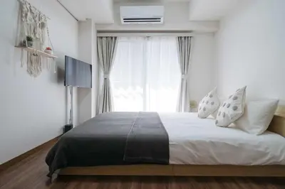 a bedroom with a large bed with a window at New \u65b0\u5bbf306 \u6b65\u884c\u81f3\u897f\u65b0\u5bbf\u7ad99\u5206\u949f JR\u5c71\u624b\u7ebf\u65b0\u5927\u4e45\u4fdd15\u5206 \u6700\u591a\u53ef\u5bb9\u7eb33\u4eba \u9002\u5408\u4e00\u5bb6\u4e09\u53e3 \u60c5\u4fa3\u5165\u4f4f \u5355\u4eba\u65c5\u884c in Tokyo