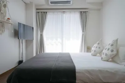 a bedroom with a large bed and a window at New \u65b0\u5bbf306 \u6b65\u884c\u81f3\u897f\u65b0\u5bbf\u7ad99\u5206\u949f JR\u5c71\u624b\u7ebf\u65b0\u5927\u4e45\u4fdd15\u5206 \u6700\u591a\u53ef\u5bb9\u7eb33\u4eba \u9002\u5408\u4e00\u5bb6\u4e09\u53e3 \u60c5\u4fa3\u5165\u4f4f \u5355\u4eba\u65c5\u884c in Tokyo