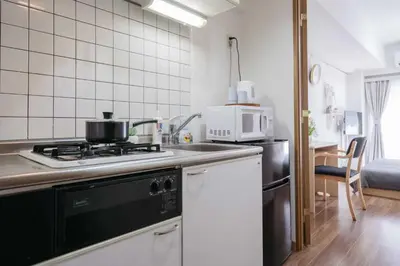 a kitchen with a stove and a microwave at New \u65b0\u5bbf306 \u6b65\u884c\u81f3\u897f\u65b0\u5bbf\u7ad99\u5206\u949f JR\u5c71\u624b\u7ebf\u65b0\u5927\u4e45\u4fdd15\u5206 \u6700\u591a\u53ef\u5bb9\u7eb33\u4eba \u9002\u5408\u4e00\u5bb6\u4e09\u53e3 \u60c5\u4fa3\u5165\u4f4f \u5355\u4eba\u65c5\u884c in Tokyo