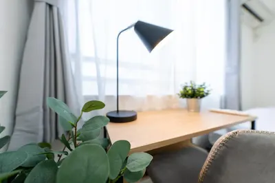 a desk with a lamp and a table with chairs at FINOA Residential Suite Takaido in Tokyo