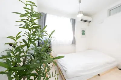 a bedroom with a bed and a plant at FINOA Residential Suite Takaido in Tokyo
