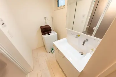 a bathroom with a sink and a refrigerator at FINOA Residential Suite Takaido in Tokyo