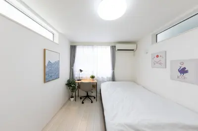 a small bedroom with a bed and a desk at FINOA Residential Suite Takaido in Tokyo