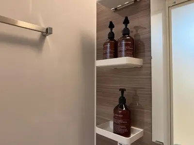 a bathroom with three bottles of alcohol on shelves at FINOA Residential Suite Takaido in Tokyo