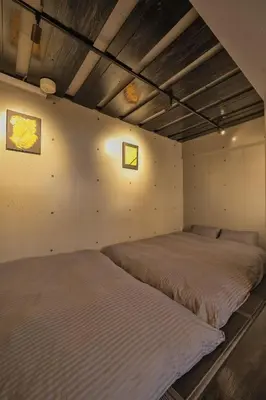two beds in a room with a wall at BO101 \u5bb6\u65cf\u65c5\u306b\u6700\u9069 \u6d45\u8349\u5bfa\u305d\u3070 \u65e5\u672c\u4ebaSuperHost in Tokyo