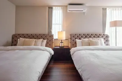 two beds in a hotel room with white sheets at Noël Shibuya Once -Luxury Residence in Tokyo