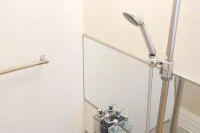 a floor lamp next to a mirror in a bathroom at Dori Dori House Ebisu in Tokyo