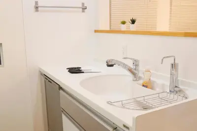 a kitchen counter with a sink and a faucet at Dori Dori House Ebisu in Tokyo