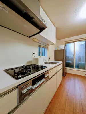 a kitchen with a stove top oven next to a sink at \u6c60\u888b\u672c\u753a303 in Tokyo