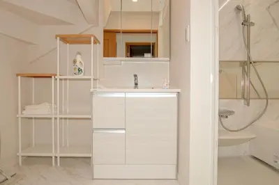 a white bathroom with a sink and a shower at \u6c60\u888b\u672c\u753a303 in Tokyo