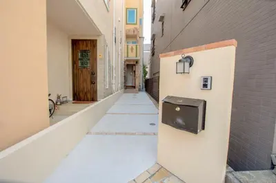 an empty alley with a trash can on the side of a building at \u6c60\u888b\u672c\u753a303 in Tokyo
