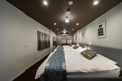 a large bed in a room with white walls at \u30a2\u30f3\u30c9\u30b9\u30c6\u30a4\u5800\u52076\u4e01\u76ee in Tokyo