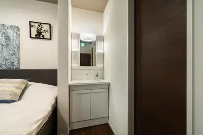 a bedroom with a bed and a sink and a mirror at \u30a2\u30f3\u30c9\u30b9\u30c6\u30a4\u5800\u52076\u4e01\u76ee in Tokyo