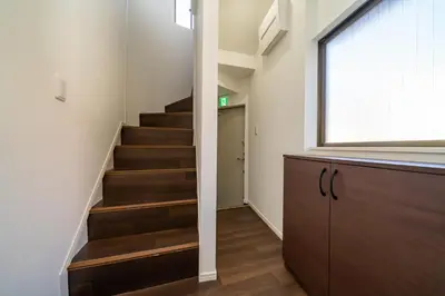 a hallway with stairs and a window and a door at \u30a2\u30f3\u30c9\u30b9\u30c6\u30a4\u5800\u52076\u4e01\u76ee in Tokyo