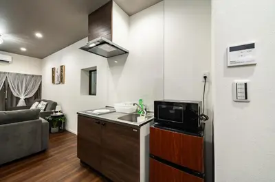 a small kitchen with a microwave and a living room at \u30a2\u30f3\u30c9\u30b9\u30c6\u30a4\u5800\u52076\u4e01\u76ee in Tokyo