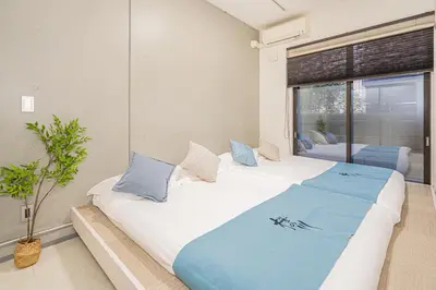 a bedroom with two beds and a large window at \u685c\u306e\u5ddd70-36\u6c60\u888b\u99c58\u5206\u949f 1DK\u5957\u623f max5\u4eba\u623f \u5bbd\u655e\u5b89\u9759 ikeburuko in Tokyo