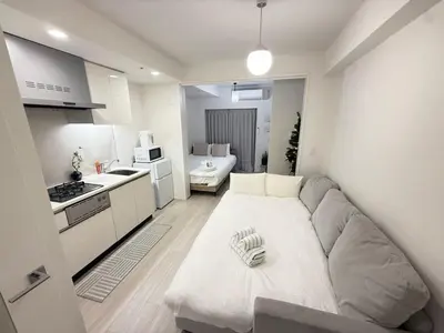 a living room with a couch and a kitchen at Ying-Higashi Shinjuku-SJ0061 in Tokyo