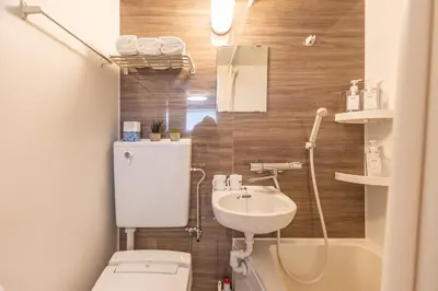 a small bathroom with a toilet and a sink at Shinjuku two stations, three-bedroom apartment, 6 people, seven minutes from Higashi-Nakano station in Tokyo