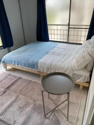 a bed with a table and a chair in a room at Dolce Vita Ebisu in Tokyo