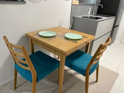 a wooden table and two chairs with plates and wine glasses at Dolce Vita Ebisu in Tokyo