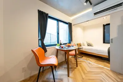 a room with a bed and a table and chairs at GLANNIR Higashi kitazawa 102 in Tokyo