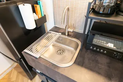 a kitchen counter with a sink and a microwave at GLANNIR Higashi kitazawa 102 in Tokyo